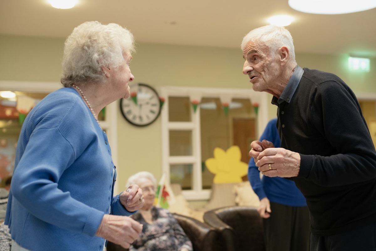 Two older women sitting and talking at a gathering